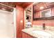 Bathroom featuring granite countertops, wood paneling, and a shower at 85 Revett Dr # 66, Breckenridge, CO 80424