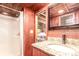 Bathroom featuring granite countertops, wood paneling, and a shower at 85 Revett Dr # 66, Breckenridge, CO 80424
