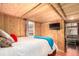 Well-lit bedroom featuring wood walls, an exterior window, and a comfy bed at 85 Revett Dr # 66, Breckenridge, CO 80424