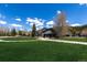 Beautifully landscaped exterior of a rural home with lush lawn and mature trees set against a bright blue sky at 85 Revett Dr # 66, Breckenridge, CO 80424