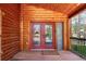 Elegant red double doors with glass panels, leading into a cozy cabin-style home with natural wood accents at 85 Revett Dr # 66, Breckenridge, CO 80424