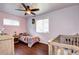 Cozy bedroom with hardwood floors, ceiling fan, and windows for natural light at 1215 S Ivanhoe Way, Denver, CO 80224