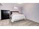 Carpeted bedroom with bed and dark furniture with an overhead light and small window at 1215 S Ivanhoe Way, Denver, CO 80224