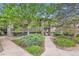 View of the condo from the street and a walking path through a landscaped yard at 695 Manhattan Dr # 109, Boulder, CO 80303