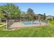 Community pool surrounded by grass and a low metal fence at 695 Manhattan Dr # 109, Boulder, CO 80303