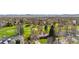 High-angle view of a single story home nestled near a verdant golf course, surrounded by mature trees and other houses at 16 Wedge Way, Littleton, CO 80123
