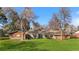 Expansive backyard featuring a well-maintained lawn, mature trees, and a brick home with large windows at 16 Wedge Way, Littleton, CO 80123