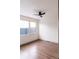 Hardwood floor bedroom with ceiling fan and large window at 860 S Quivas St, Denver, CO 80223