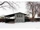 Gray house with black accents, covered carport, and snowy yard at 860 S Quivas St, Denver, CO 80223