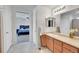 Bathroom showcasing double sinks, a large mirror, and an open doorway to the bedroom at 4261 Threshing Dr, Brighton, CO 80601