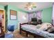 Bedroom with turquoise walls, a daybed, a rainbow fan, and natural light from the window at 10150 W 25Th Ave, Lakewood, CO 80215