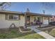 Charming home featuring a covered porch and well-manicured flower beds, creating inviting curb appeal at 10150 W 25Th Ave, Lakewood, CO 80215