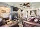 Open living area with hardwood floors, brick fireplace, ceiling fan, and comfortable leather couches at 10150 W 25Th Ave, Lakewood, CO 80215