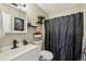 Cozy bathroom with sleek black fixtures, decorative shelves, and black shower curtain at 1272 S Uvalda St, Aurora, CO 80012
