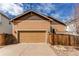 Exterior shot of a house showing a tan siding, garage door, driveway, and partial fence at 4322 N Meadows Dr, Castle Rock, CO 80109