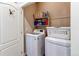 Bright laundry room features a white washer and dryer, plus storage shelves for supplies at 4322 N Meadows Dr, Castle Rock, CO 80109