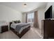 Bright bedroom with neutral tones, a large window, and a comfortable-looking queen-size bed and a large TV at 8390 S Cody Way, Littleton, CO 80128