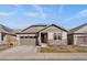 Inviting single-story home showcasing a well-maintained front lawn, stone accents, and a two-car garage at 8390 S Cody Way, Littleton, CO 80128