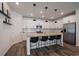 Bright kitchen features white cabinetry, granite countertops, an island with seating, and stainless-steel appliances at 8390 S Cody Way, Littleton, CO 80128