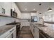 Modern kitchen with white cabinets, granite countertops, stainless steel appliances, and stylish hardwood floors at 8390 S Cody Way, Littleton, CO 80128
