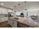 Bright, open kitchen featuring a large island, stainless steel appliances, and seamless flow to the dining and living areas at 8390 S Cody Way, Littleton, CO 80128