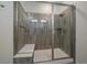 Contemporary shower featuring sleek glass doors, vertical tiling, a built-in bench, and modern fixtures at 8390 S Cody Way, Littleton, CO 80128