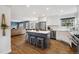 Open concept kitchen and living area featuring a kitchen island, stainless steel appliances, and hardwood floors at 787 Huntington Pl, Highlands Ranch, CO 80126