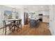 Bright eat-in kitchen featuring white cabinets, stainless steel appliances, an island with seating, and beautiful wood floors at 787 Huntington Pl, Highlands Ranch, CO 80126