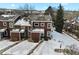 Aerial shot of townhouses with snow-covered roofs, complemented by nearby trees and mountains at 14585 W 32Nd Ave, Golden, CO 80401