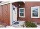 Inviting front entrance with a white door and window, complemented by lush greenery at 14585 W 32Nd Ave, Golden, CO 80401