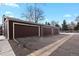 View of multiple attached brown garages with driveways for easy parking access in a communal area at 14585 W 32Nd Ave, Golden, CO 80401