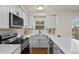 Bright kitchen with stainless steel appliances, white cabinets, and stylish black hardware fixtures at 14585 W 32Nd Ave, Golden, CO 80401