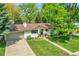 Inviting single-story home showcasing beautiful landscaping, a large lot and mature trees at 2237 Zinnia St, Golden, CO 80401