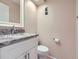 Powder room featuring granite countertop, white vanity, and a modern mirror at 14057 E Arkansas Pl, Aurora, CO 80012