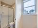 Clean bathroom featuring a glass-enclosed shower and a bright window at 14057 E Arkansas Pl, Aurora, CO 80012