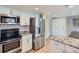 Modern kitchen with stainless steel appliances, granite countertops, and white cabinetry at 14057 E Arkansas Pl, Aurora, CO 80012