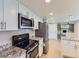 Bright kitchen featuring granite counters, stainless appliances, and adjacent living area at 14057 E Arkansas Pl, Aurora, CO 80012