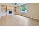 Bright living room with fireplace, built-in shelving, large window and light wood floors at 14057 E Arkansas Pl, Aurora, CO 80012