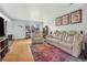 Bright living room featuring hardwood floors, a large reclining sofa, and artistic wall decor at 2557 S Dover St # 68, Lakewood, CO 80227