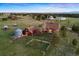 Vast property showcasing barn-style home, outbuildings, lush pastures, and mountain views at 11689 Caribou Dr, Franktown, CO 80116