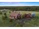 Scenic aerial shot of a barn-style house with long driveway, garage, silo and verdant surroundings at 11689 Caribou Dr, Franktown, CO 80116