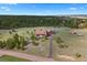 Expansive aerial view of property featuring a barn-style home, long driveway, and wooded surroundings at 11689 Caribou Dr, Franktown, CO 80116