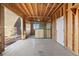 Spacious barn with wooden framing, concrete floors, and an enclosed stall area with metal gates at 11689 Caribou Dr, Franktown, CO 80116