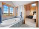 The bathroom boasts a soaking tub, large windows with views, and a connecting bedroom at 11689 Caribou Dr, Franktown, CO 80116