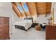 Cozy bedroom features vaulted ceiling with skylights, neutral carpet, and dresser storage at 11689 Caribou Dr, Franktown, CO 80116