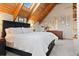 The bedroom offers vaulted wood ceilings, neutral colors, plush carpet and lovely decor at 11689 Caribou Dr, Franktown, CO 80116