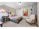 Cozy bedroom decorated with large colorful floral comforter and matching artwork and comfortable chair at 11689 Caribou Dr, Franktown, CO 80116