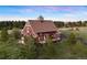 Beautiful barn-style home with gabled roof, covered porch, and surrounded by lush greenery at 11689 Caribou Dr, Franktown, CO 80116