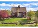 Beautiful property with lush green lawn, mature trees, and stone-lined pathway leading to the residence at 11689 Caribou Dr, Franktown, CO 80116