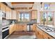Kitchen showcasing wood cabinetry, stainless steel appliances, tile backsplash, and a large window view of outdoors at 11689 Caribou Dr, Franktown, CO 80116